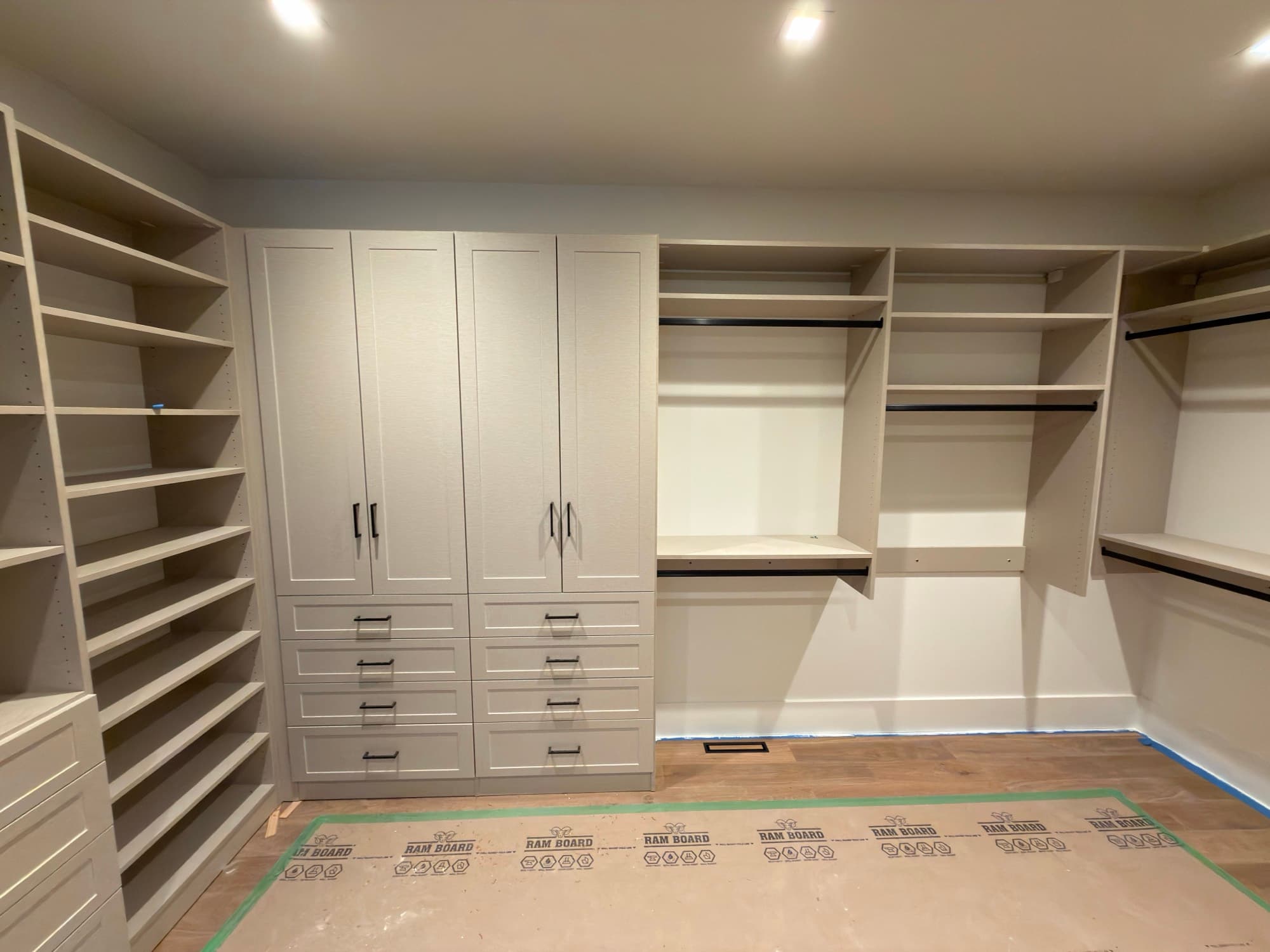 Walk-in closet with island, hanging, drawers, and shoe storage