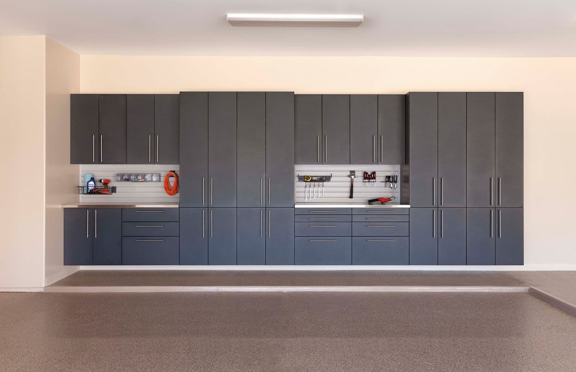 Garage wall of gray cabinets with slatwall